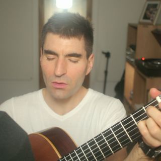 A thumbnail from the music video featuring me playing the guitar and signing. Une vignette du clip vidéo dans laquelle je joue de la guitare et chante.